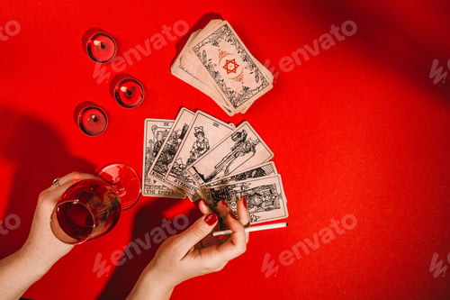 Preview: Tarot cards and female hands of fortune teller on red background