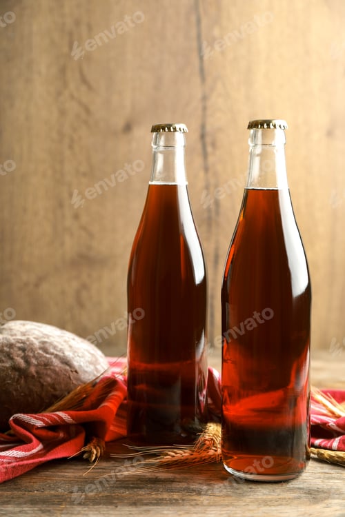 Preview: Bottles of delicious fresh kvass, spikelets and bread on wooden table