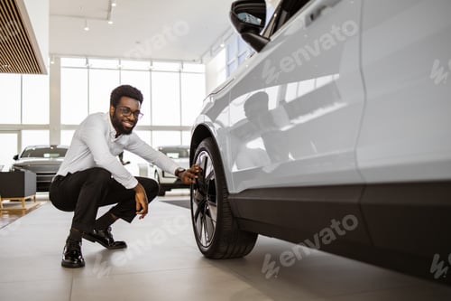 Preview: Side view of customer, buyer, client in white shirt chooses auto.