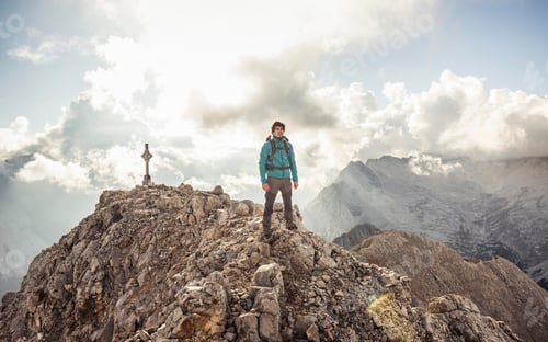 Preview: Adventurer conquering the mountain peak with expansive views