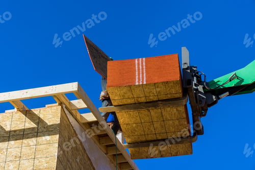 Preview: Residential house under construction worker is covering the wooden frame with plywood using