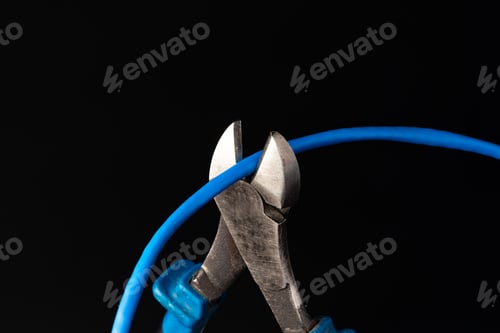 Cutting pliers cut electric cable close up
