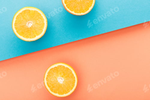 Preview: Top view of oranges halves on blue and orange background