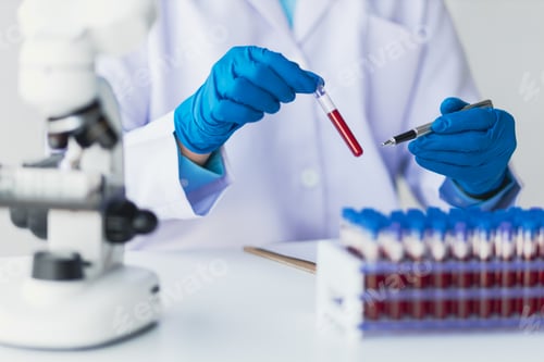 Preview: Scientists experiment with solutions in test tubes while working with a microscope in the lab.