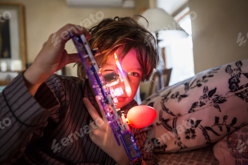 Preview: A six year old boy playing with a lit up toy at home in low light.