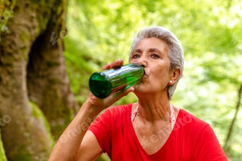 Preview: old lady with gray hair drinking water