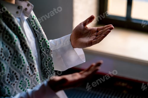 Preview: Close-up shot of a Muslim man's hands praying on his knees during Ramadan in an Islamic temple