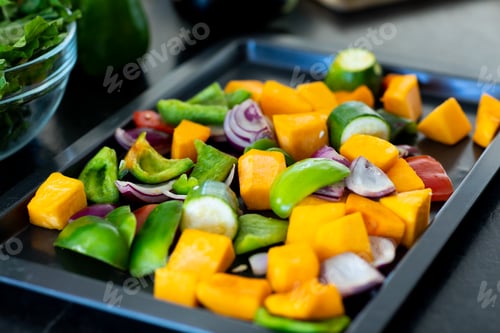 Preview: Close up of chopped vegetables in baking tray on countertop in kitchen