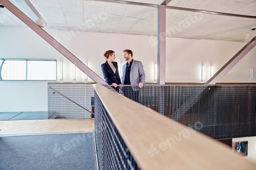Preview: Businessman and businesswoman standing on office floor
