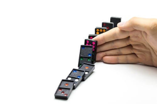 Preview: Businessman hand stopping domino effect on isolated white background with copy space