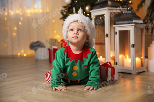 Preview: Baby in cute elf costume at home. Christmas outfit