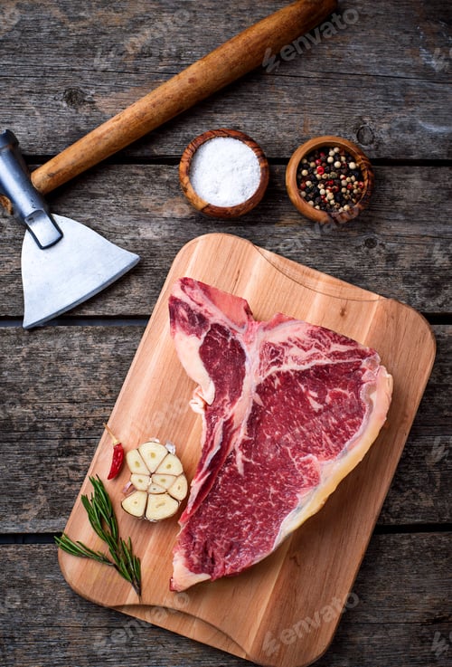 Preview: Raw T-bone steak with hatchet