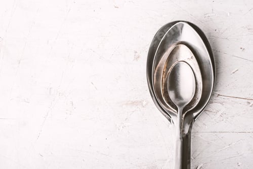 Preview: Metal spoons on the white table top view