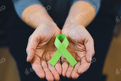 Preview: Woman's hand holding green ribbon, Cancer and Lymphoma Awareness, World cancer day