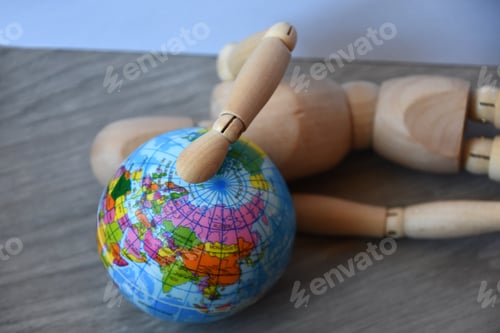 Preview: Wooden human figure holding globe planet Earth, world economic crisis