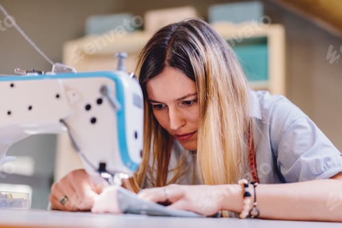 Preview: Seamstress dressmaker woman working with sewing machine in workshop