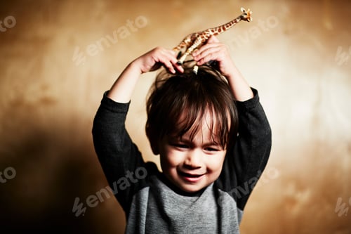 Preview: Little child plays with a toy giraffe, imagining it's on their head.