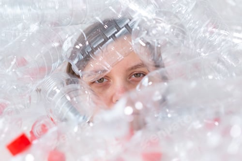 Preview: Dehydrated sick woman is lying in a pile of plastic bottles. Environmental pollution problem. Stop