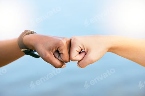 Preview: Closeup of two unknown people giving each other a fist bump against blue copyspace. Female friends