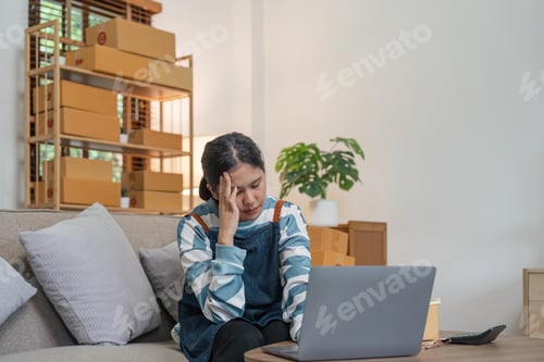 Preview: Small online business owner Asian woman wearing apron stressed headache taking Less sales, returned