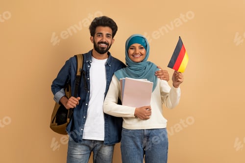 Preview: International Education. Arabic Student Couple With Backpacks Holding German Flag