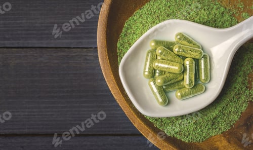Preview: Top view of Kratom powder in ceramic spoon and Kratom capsules on wooden table