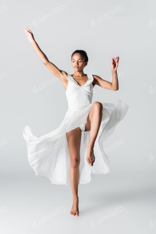 Preview: barefoot graceful african american ballerina in dress dancing on white background