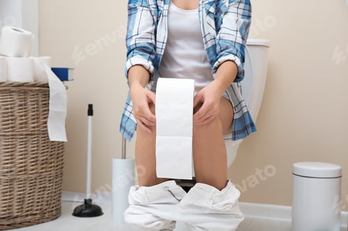 Preview: Woman with paper roll sitting on toilet bowl in bathroom