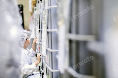 Preview: Factory worker checking paperwork on roll cage