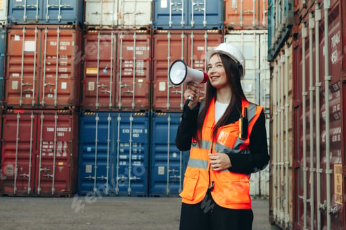 Preview: Female engineer speaking into a megaphone while standing in an industrial warehouse