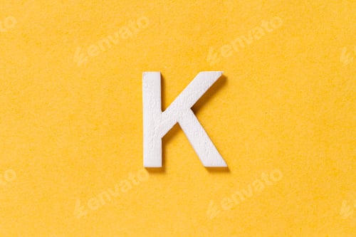 Preview: Letter K of the alphabet isolated on yellow background, top view