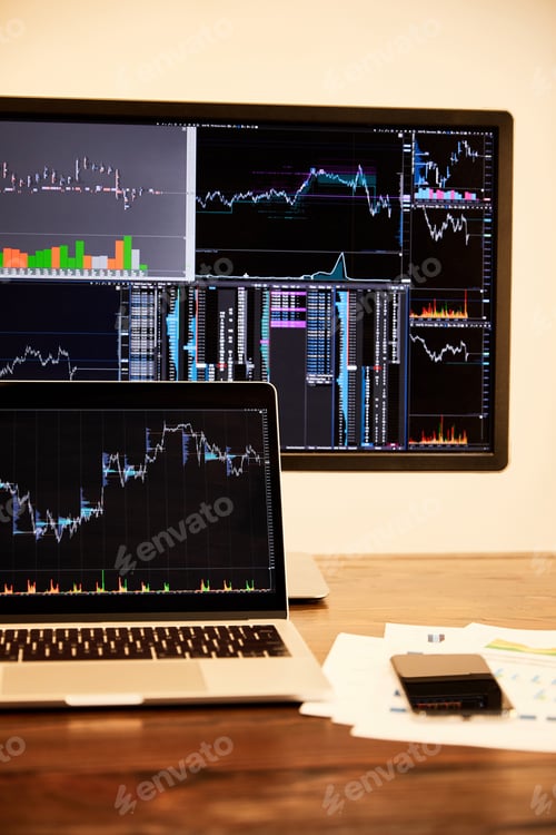 Preview: laptop and computer with charts and graphs, documents and smartphone on table