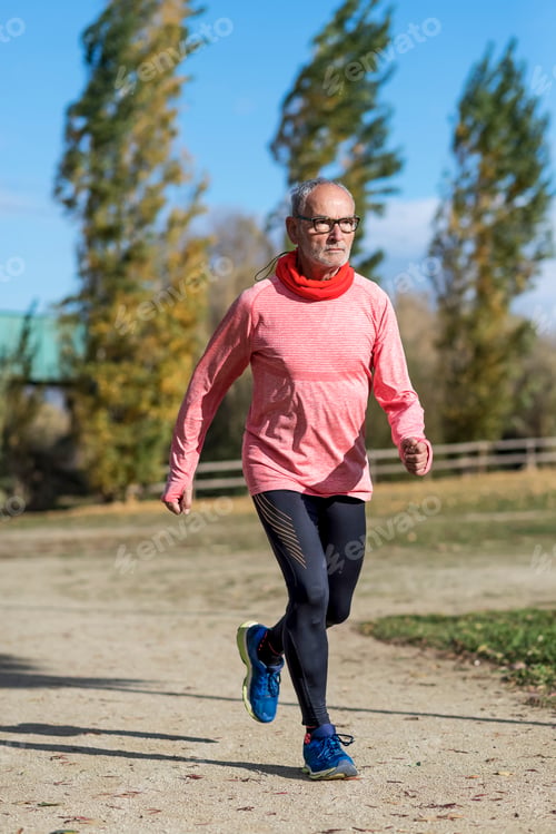 Preview: A senior man dressed in black and green is running in the park