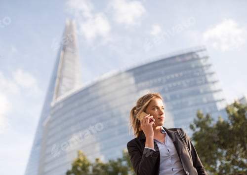 Preview: Businesswoman making call, buildings in background, London, UK