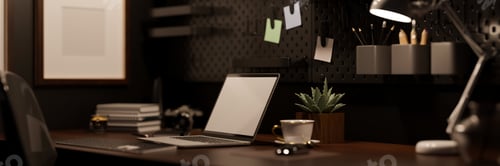 Preview: Modern hipster dark office workplace with laptop on wood table over the black wall