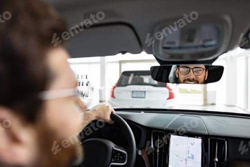 Preview: Businessman driving new car inside vehicle showroom