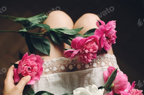 Preview: lovely pink peonies on legs of boho girl in white bohemian dress