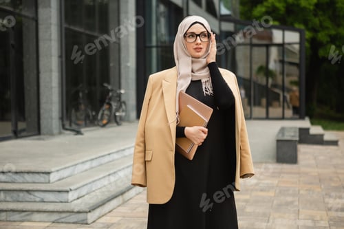 Preview: modern stylish muslim woman in hijab in city street