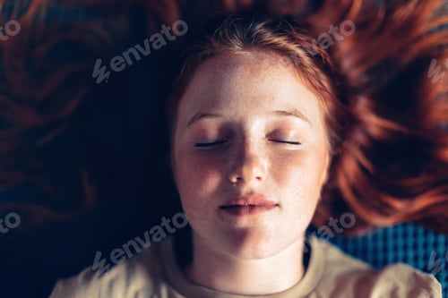 Preview: close-up portrait of caucasian girl with freckles and red hair with closed eyes
