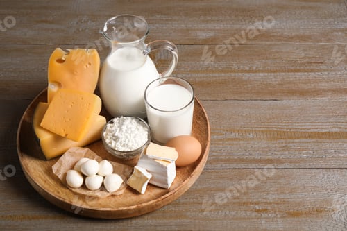 Preview: Different delicious dairy products on wooden table. Space for text