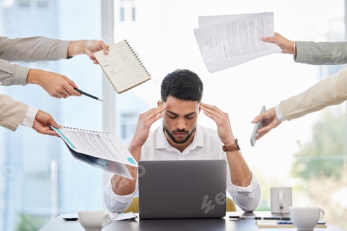 Preview: I just want to be left alone. Shot of a young businessman looking stressed at work.
