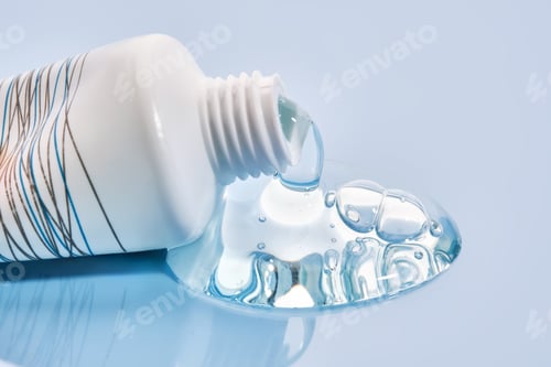 Preview: Shampoo pouring out of a small tube on a blue background. Texture.