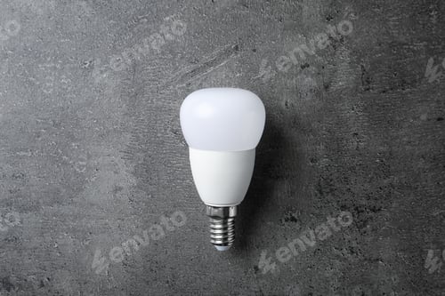 Preview: New modern lamp bulb on grey stone surface, top view