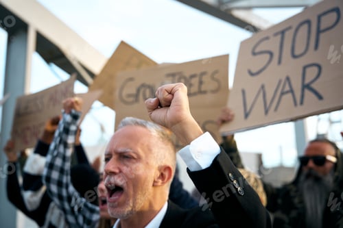 Preview: Adult grey haired man in suit with group of diverse people protesting angry shouting against war