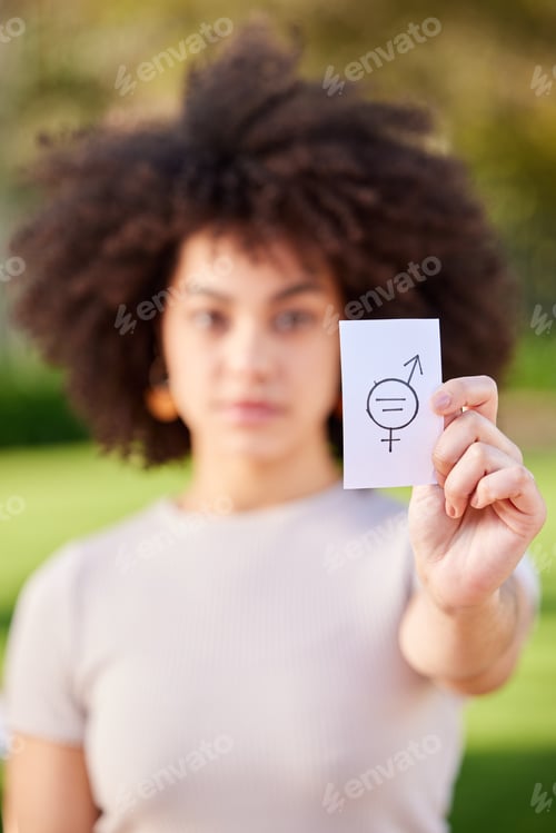 Preview: Shot of a young woman holding a card in protest in a park
