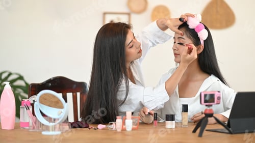 Preview: Women are showing how to make up via online video at the wooden dressing table.