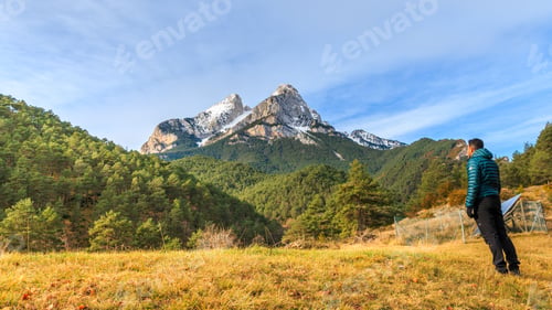 Preview: Mesmerizing shot of a young male standing in front of the Pedraforca Saldes Mountain in Spain