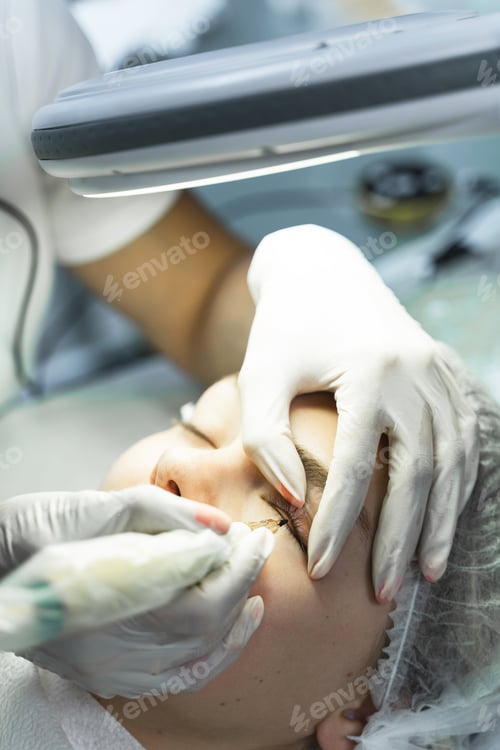 Preview: Young woman during professional permanent makeup treatment
