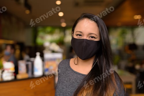 Preview: Face of woman wearing medical face mask for protection against coronavirus Covid-19