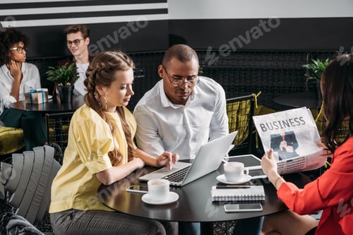 Preview: young successful business partners looking at laptop together